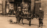 Three young men, the one holding the donkey is wearing a Salvation Army Uniform they are outside Frank Casson's shop which was a Chemist & Druggist and dealer in Paint Colours, Seeds Etc.